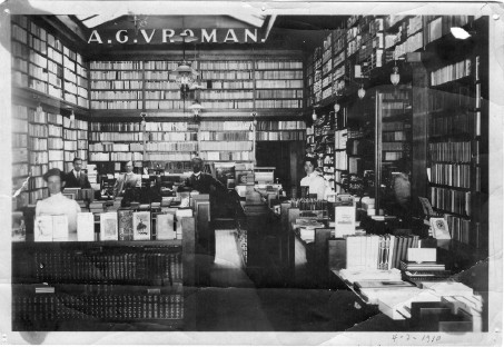 Black and white photo of the inside of the old store front, wall to wall shelves filled with books